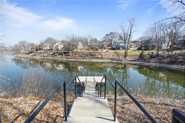 view of dock with a residential view and a water view