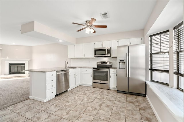 kitchen featuring visible vents, ceiling fan, appliances with stainless steel finishes, white cabinetry, and a sink