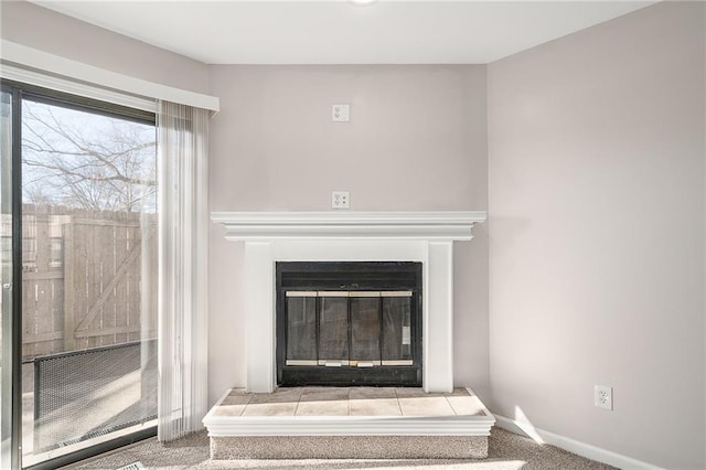 room details with a glass covered fireplace, baseboards, and carpet