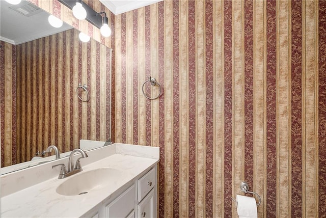 bathroom with vanity, wallpapered walls, and ornamental molding