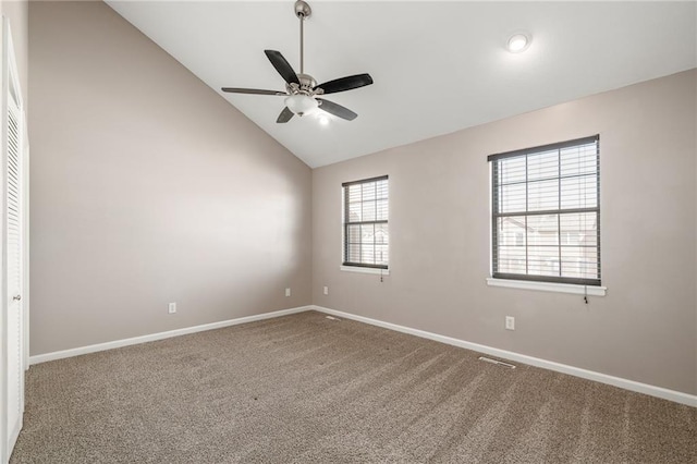 carpeted spare room with baseboards, lofted ceiling, visible vents, and ceiling fan