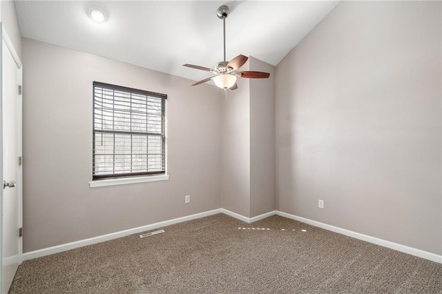 carpeted spare room with visible vents, baseboards, ceiling fan, and vaulted ceiling