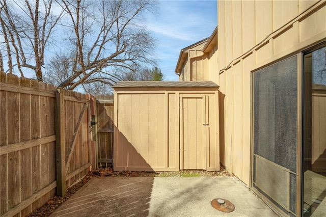 exterior space featuring a gate, a storage unit, an outbuilding, and fence