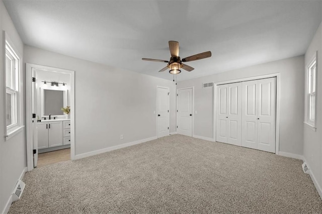 unfurnished bedroom with light colored carpet, baseboards, and multiple windows