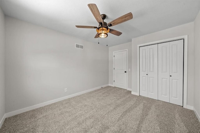 unfurnished bedroom with carpet, visible vents, a closet, and baseboards