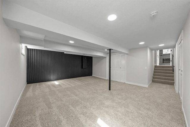 finished basement featuring stairway, recessed lighting, baseboards, and carpet floors