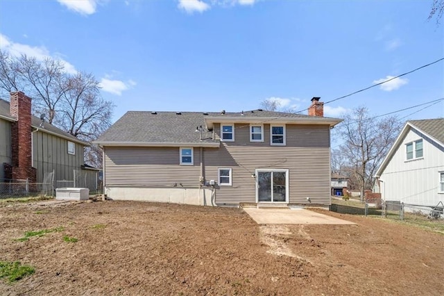 rear view of house with a patio area, a chimney, and fence