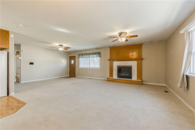 unfurnished living room featuring visible vents, light colored carpet, and a ceiling fan