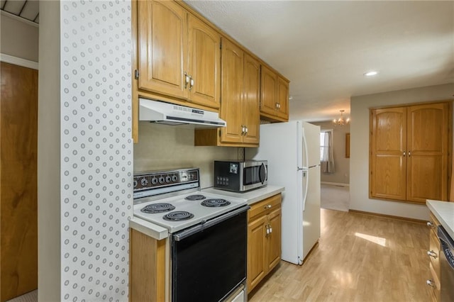 kitchen featuring under cabinet range hood, stainless steel appliances, and light countertops