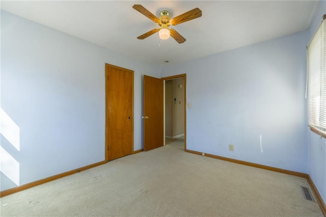 empty room with visible vents, baseboards, ceiling fan, and carpet flooring