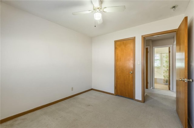 unfurnished bedroom with light carpet, a ceiling fan, and baseboards