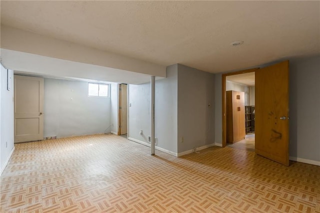 basement featuring baseboards and a textured ceiling