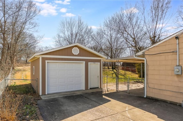 detached garage featuring concrete driveway, a gate, and fence