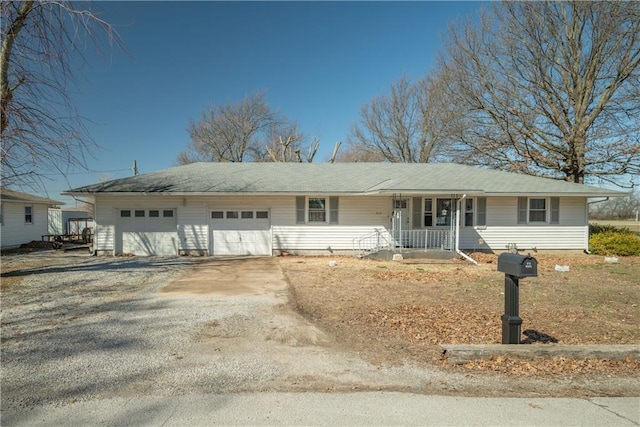 single story home featuring a porch, a garage, and driveway