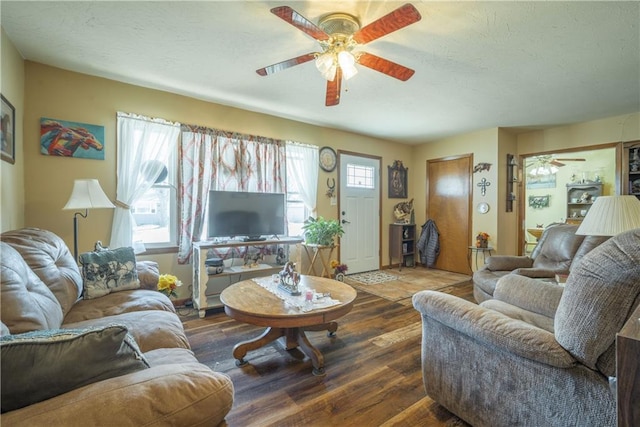 living area with a textured ceiling, wood finished floors, a wealth of natural light, and ceiling fan