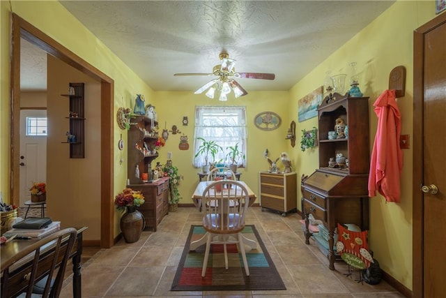 tiled dining room featuring baseboards, plenty of natural light, a textured ceiling, and ceiling fan