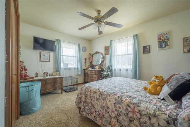 bedroom featuring multiple windows, carpet floors, and a ceiling fan