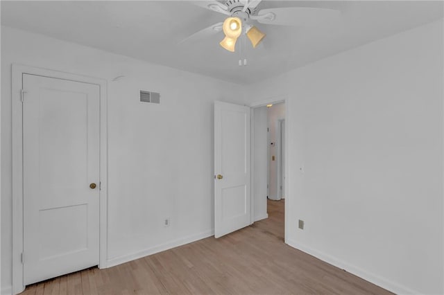 unfurnished bedroom featuring visible vents, baseboards, wood finished floors, and a ceiling fan