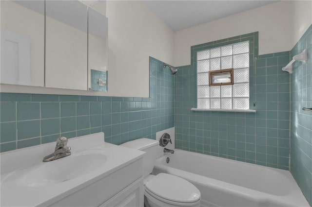 full bathroom featuring vanity, tile walls, toilet, and shower / bathtub combination