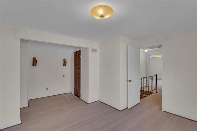 spare room with visible vents, baseboards, and light wood-style floors