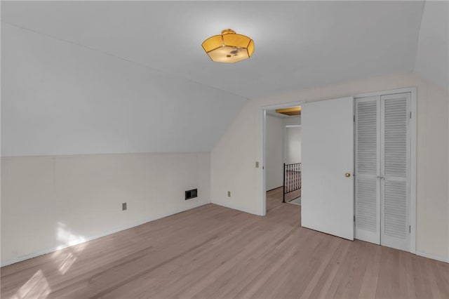 bonus room featuring vaulted ceiling, light wood-style floors, and visible vents