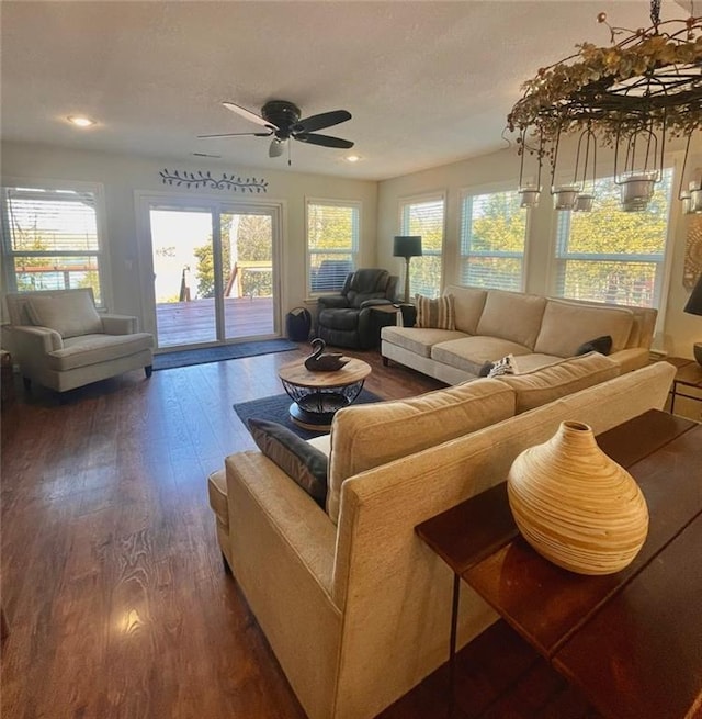 living room featuring a wealth of natural light, dark wood-type flooring, and a ceiling fan