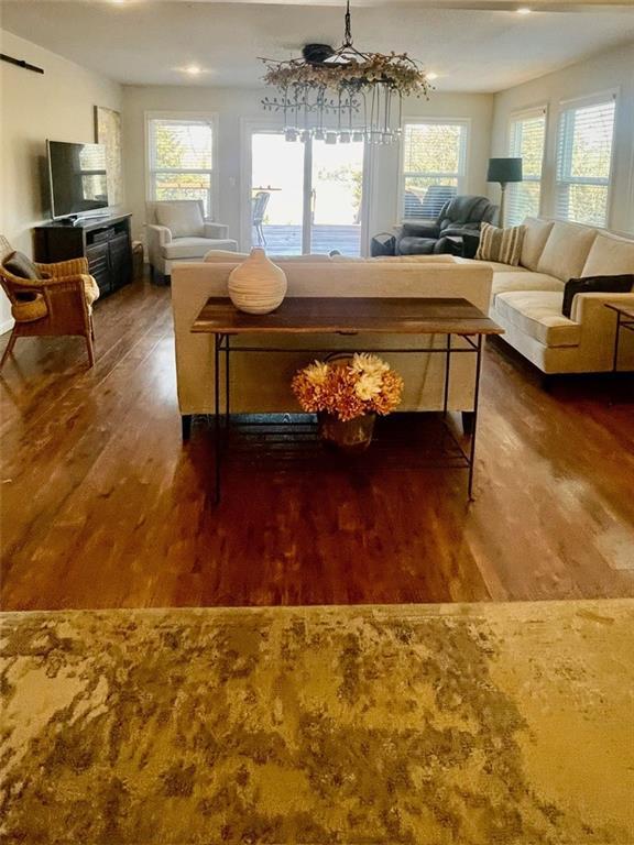 living area featuring an inviting chandelier and wood finished floors