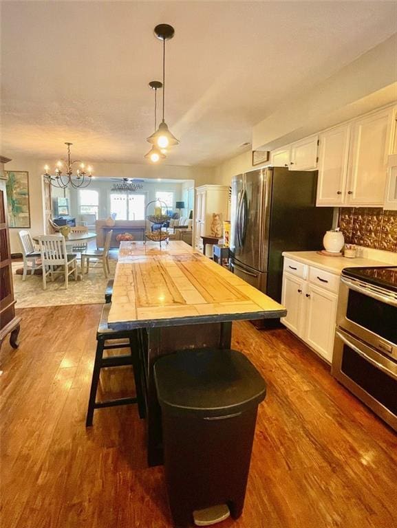 kitchen featuring dark wood-type flooring, white cabinets, light countertops, and stainless steel appliances