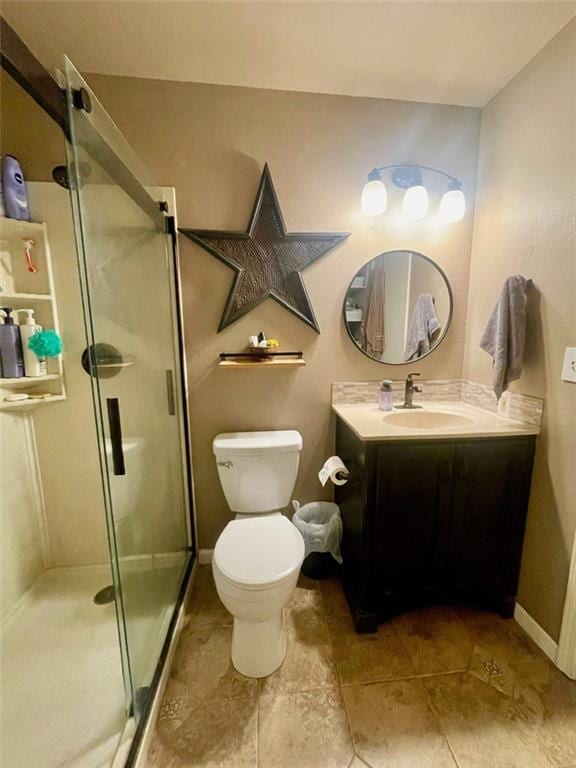 full bath with vanity, toilet, baseboards, and a stall shower