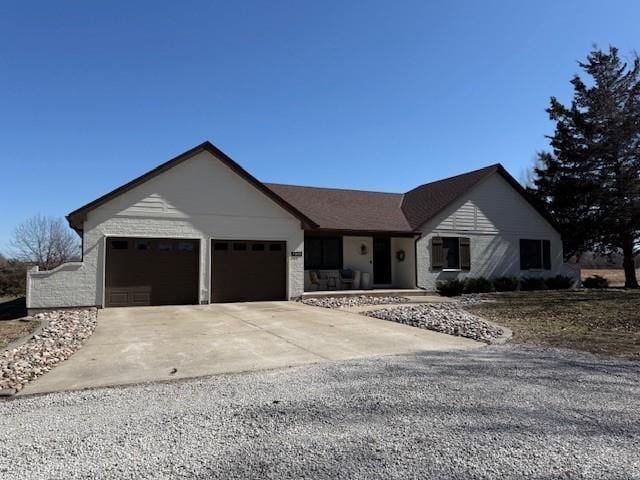 ranch-style home featuring a garage and driveway