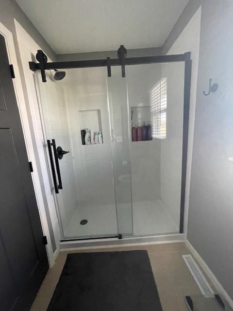 full bathroom featuring baseboards, a shower stall, and tile patterned flooring