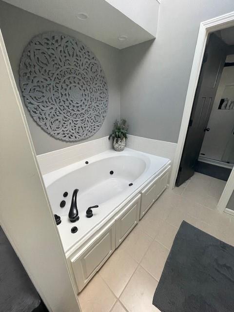 full bath with tile patterned flooring, a shower stall, and a garden tub