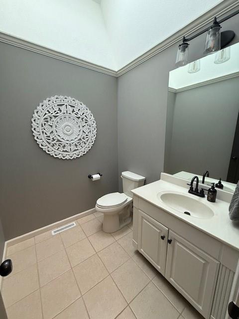 half bath featuring visible vents, baseboards, toilet, tile patterned floors, and vanity