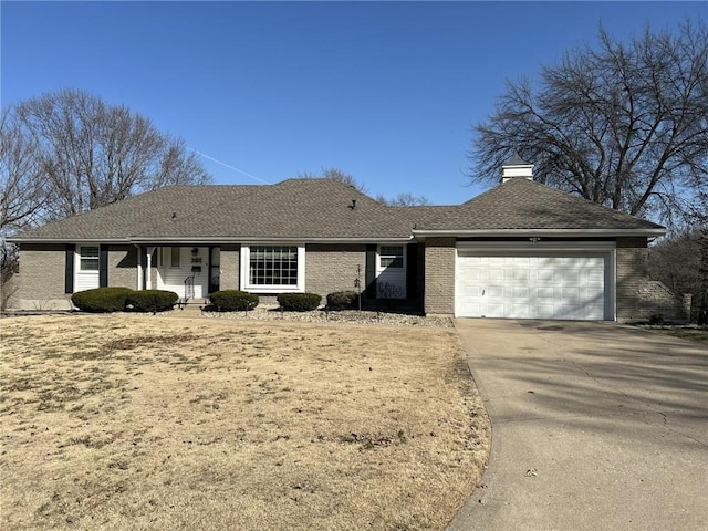 ranch-style house featuring an attached garage, a shingled roof, a chimney, concrete driveway, and brick siding