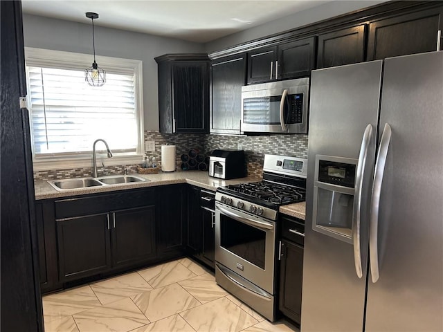 kitchen with tasteful backsplash, stainless steel appliances, dark cabinetry, and a sink