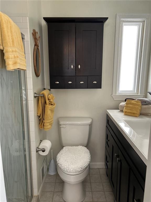 full bath featuring vanity, baseboards, a tile shower, tile patterned flooring, and toilet