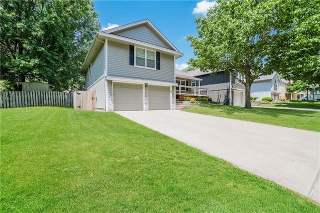 view of front of home with driveway, an attached garage, a front yard, and fence