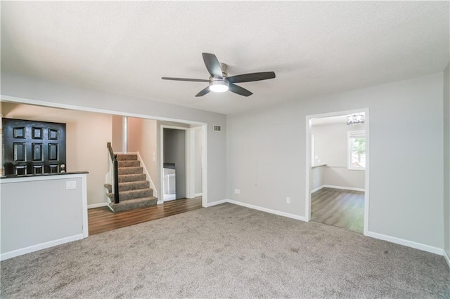 unfurnished living room with stairway, baseboards, visible vents, and carpet floors