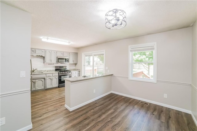 kitchen featuring light countertops, wood finished floors, appliances with stainless steel finishes, and a sink