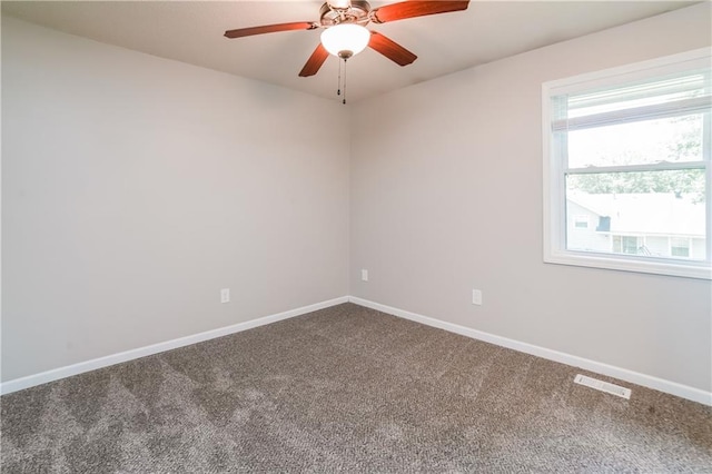 carpeted empty room with visible vents, ceiling fan, and baseboards