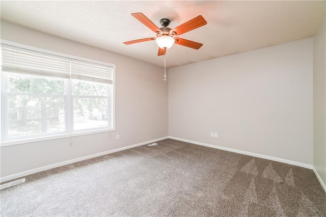 spare room with baseboards, carpet, visible vents, and a textured ceiling