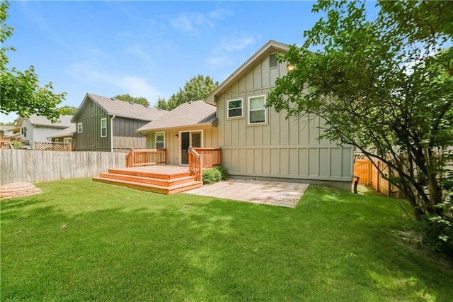 back of house with a yard, fence private yard, board and batten siding, and a wooden deck