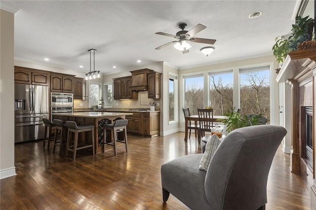 16520 NW 178th St, Platte City, MO 64079 - living area featuring crown molding, a ceiling fan, a fireplace, dark wood-type flooring, and a textured ceiling