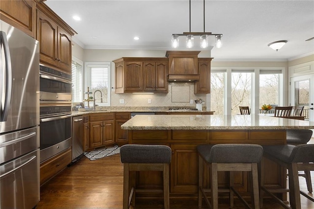 16520 NW 178th St, Platte City, MO 64079 - kitchen with stainless steel appliances, custom range hood, ornamental molding, a breakfast bar area, and a kitchen island