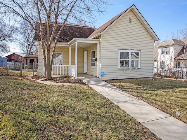 view of front of house featuring a porch, fence, and a front lawn