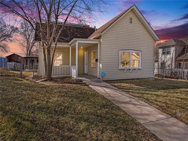 view of front of home with a front lawn, fence, and covered porch