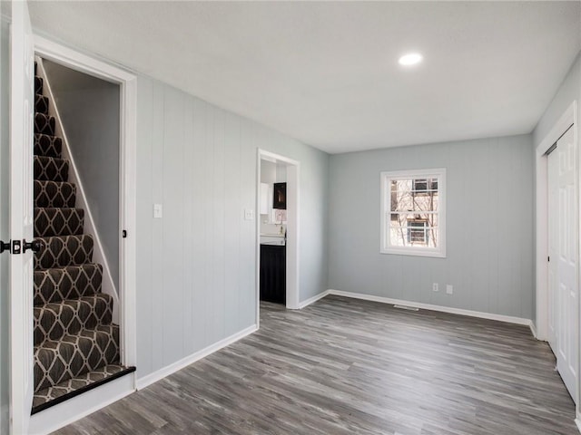 unfurnished living room with wood finished floors and baseboards