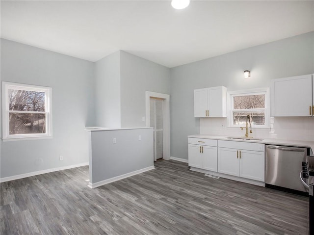 kitchen featuring a sink, dishwasher, white cabinets, and light countertops