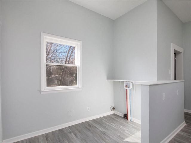 laundry room with laundry area, washer hookup, baseboards, and wood finished floors