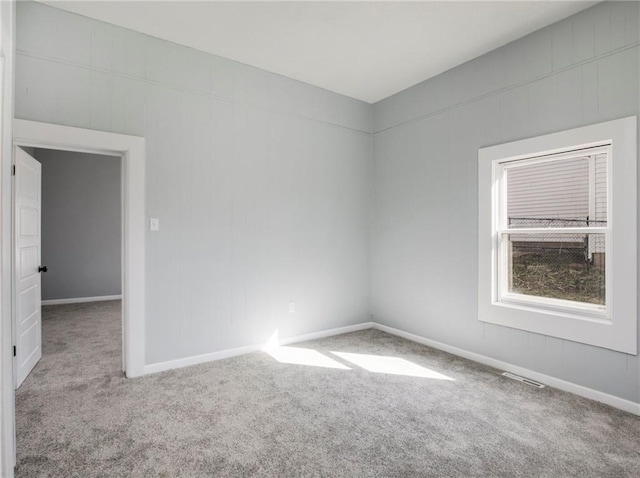 carpeted spare room featuring baseboards